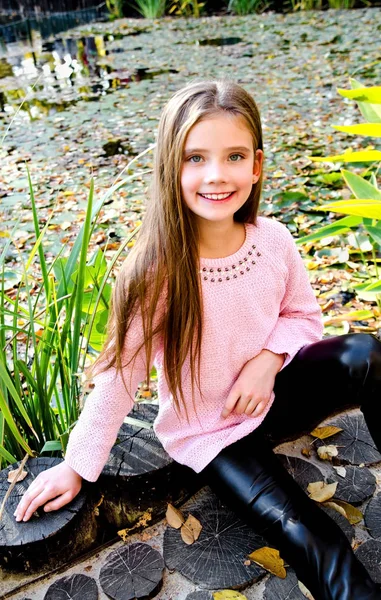 屋外の公園で愛らしい笑みを浮かべて小さな女の子子供の秋の肖像画 — ストック写真