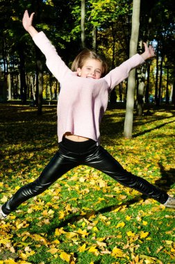 Çok güzel mutlu atlama küçük kız çocuğu açık havada sonbahar portresi
