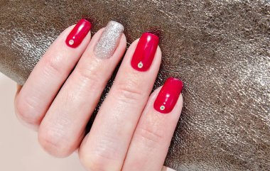 Kadının çivi ile güzel kırmızı moda tasarım taşlar ile manikür     