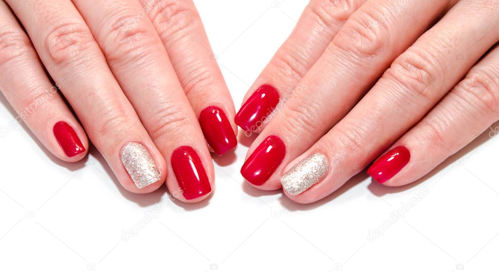 Woman's nails with beautiful red manicure fashion design with gems isolated on a white