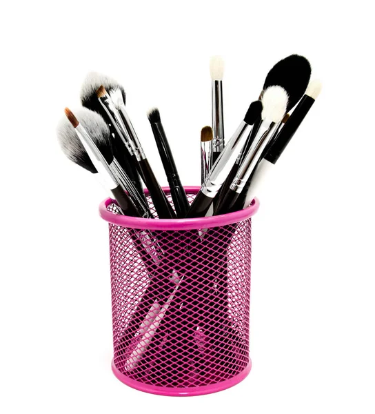 Various set of professional makeup brushes in the holder isolate