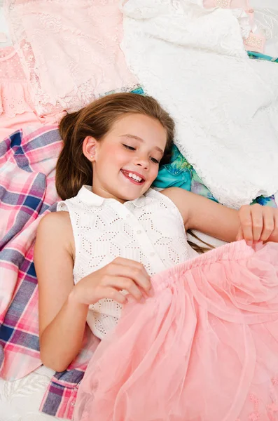 Portrait of smiling happy little girl child schoolgirl lying on — Stock Photo, Image