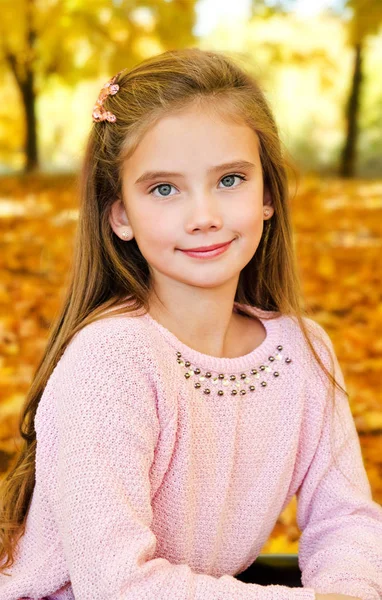 Herbstporträt eines bezaubernd lächelnden kleinen Mädchens mit Blatt — Stockfoto