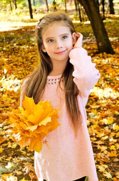 Retrato otoñal de adorable niña sonriente con hoja —  Fotos de Stock