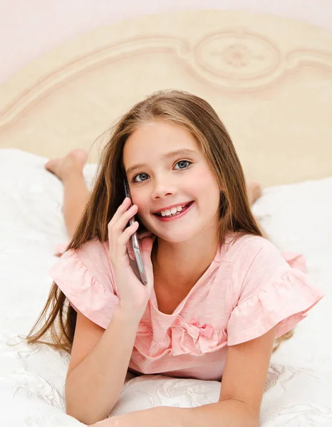 Portrait de mignonne petite fille souriante appelant par téléphone cellulaire — Photo