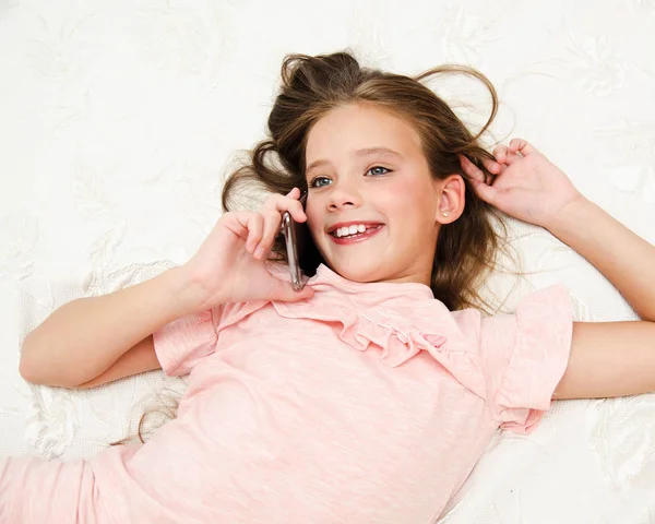 Porträt des niedlichen lächelnden kleinen Mädchens, das per Handy anruft — Stockfoto