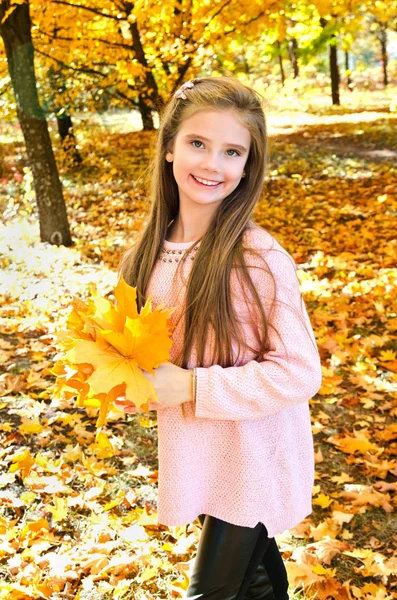 Осінній портрет чарівної усміхненої маленької дівчинки з листям — стокове фото