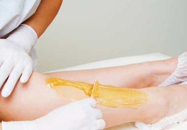 Spa merkezinde kozmetoloji uzmanı güzellik balmumu kadın bacakları olmak