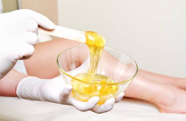 De için sıcak balmumu ile kozmetolojist güzellik ustası tutma kase