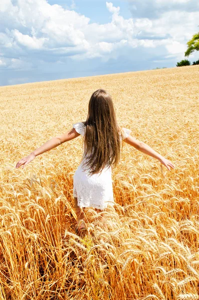 Portrait of smiling cute little girl child running through field — Stock Photo, Image