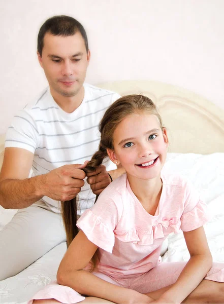 Niña sonríe mientras su padre está trenzando h hija —  Fotos de Stock