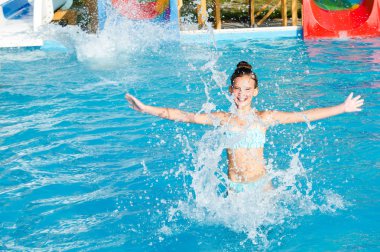 Sevimli gülümseyen küçük kız çocuk yüzme havuzunda eğlenmek 