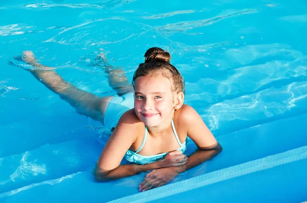Linda niña sonriente divirtiéndose en la piscina — Foto de Stock