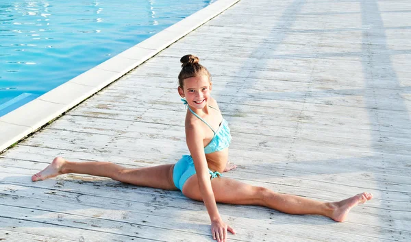 Gimnastyk dziewczynka dziecko robi akrobyczne ćwiczenia na zewnątrz na — Zdjęcie stockowe
