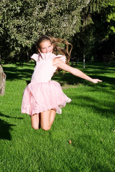 Adorable niña feliz niño está saltando y divertirse en th —  Fotos de Stock