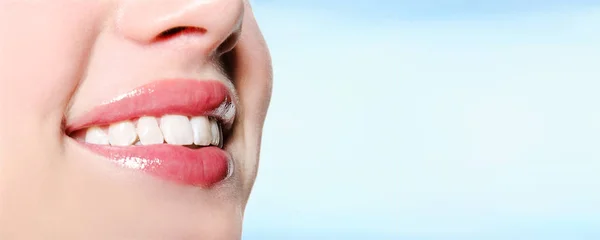 Lachende vrouw mond met grote witte tanden op een blauwe achtergrond — Stockfoto