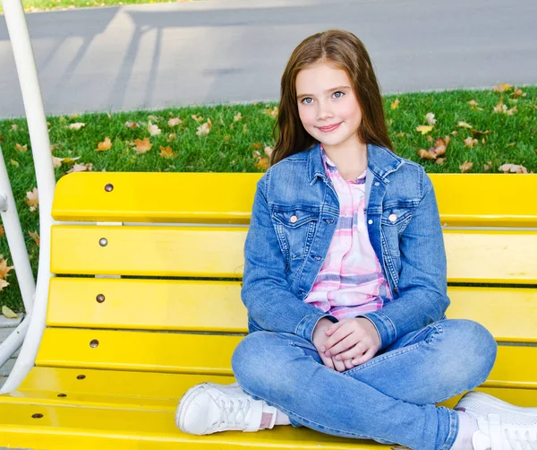 Portrait of adorable smiling little girl child sitting in the pa — Stock Photo, Image