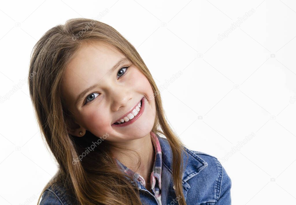 Portrait of adorable smiling little girl child preteen sitting isolated on a white background