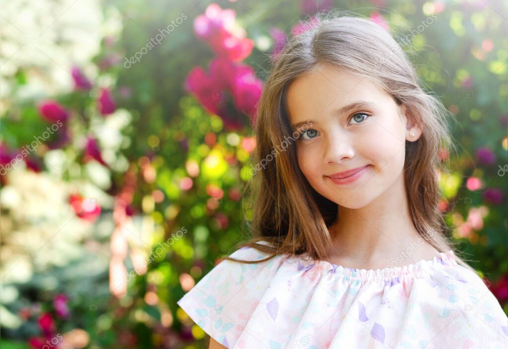 Portrait of adorable smiling little girl child in summer day. Happy preteen in the park outdoors 