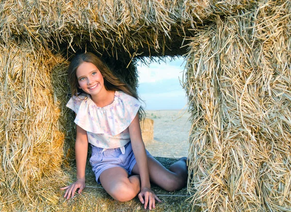 Gün Batımında Samanlıkta Yuvarlanan Sevimli Mutlu Küçük Kız Çocuğu — Stok fotoğraf
