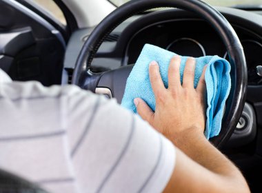 Arabanın içini ve tekerleğini temizliyorum. Erkek el dezenfekte vihicle virüs hastalığından korunmak için