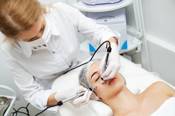 Woman getting ultrasound face beauty treatment in medical spa center. Skin rejuvenation concept