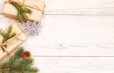 Mutlu Noeller ve duvar kağıtları. Mutlu yıllar kompozisyonu. Noel hediyesi, çam kozalakları, tahta beyaz arka planda köknar dalları. Üst görünüm ve kopyalama alanı