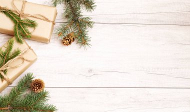 Mutlu Noeller ve duvar kağıtları. Mutlu yıllar kompozisyonu. Noel hediyesi, çam kozalakları, tahta beyaz arka planda köknar dalları. Üst görünüm ve kopyalama alanı