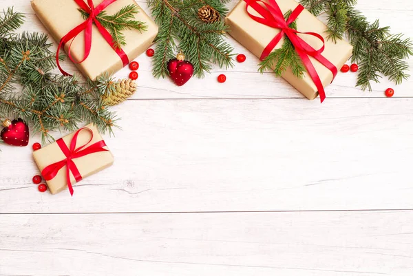 圣诞快乐的框架和壁纸 新年快乐作曲 采购产品圣诞礼物 红色的浆果 心形的球 冷杉枝在木制的白色背景 顶部视图和复制空间 — 图库照片