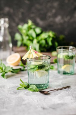Beton arka planda salatalık, limon ve nane ile sağlıklı su.