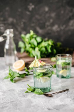 Beton arka planda salatalık, limon ve nane ile sağlıklı su.