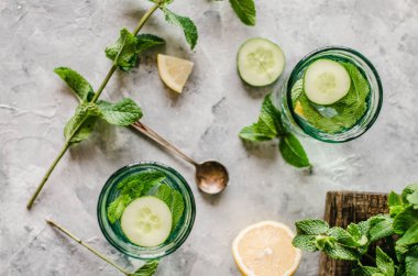 Beton arka planda salatalık, limon ve nane ile sağlıklı su.