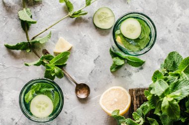 Beton arka planda salatalık, limon ve nane ile sağlıklı su.