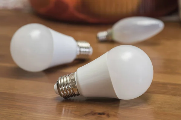 Electric light bulb on a brown desk Stock Picture