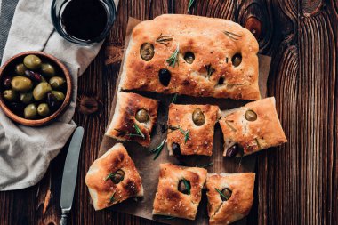 Focaccia zeytin ve biberiye ahşap arka plan üzerinde. Tonlu görüntü. Üstten görünüm.