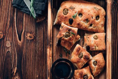 Focaccia zeytin ve biberiye ahşap arka plan üzerinde. Tonlu görüntü. Üstten görünüm.