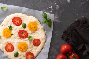Hamur pizza veya focaccia malzemeler, domates, fesleğen, zeytinyağı ile için. Üstten görünüm.