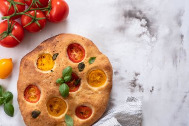 Focaccia domates ve fesleğen ile. İtalyan ekmeği. Üstten görünüm. Kopya alanı.