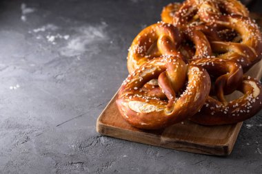 Rustik masada tuz ile taze pişmiş ev yapımı yumuşak pretzel. Octoberfest için mükemmel. 
