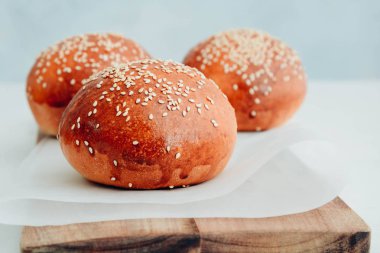 Yuvarlak topuz, susam çörek, ekmek rulo. Ahşap üzerine susam ile lezzetli hamburger ekmeği. Taze pişmiş hamburger ekmeği.