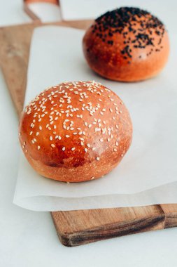 Yuvarlak topuz, susam çörek, ekmek rulo. Ahşap üzerine susam ile lezzetli hamburger ekmeği. Taze pişmiş hamburger ekmeği.