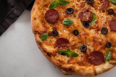 Beyaz taş zemin üzerine sıcak biberli pizza. Lezzetli pizza salam, peynir ve domates beyaz tablo, üstten görünüm