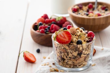 Sağlıklı kahvaltı. Taze gevrek, müsli bir cam kavanoza. Uzay kopyalayın. Organik yulaf, badem, taze berry, süt, ayçiçeği tohumu.