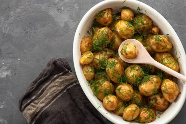 Fırında patates kavurma Tavada sarımsak, dereotu ve soğan siyah bir arka plan ile. Kopya alanı.