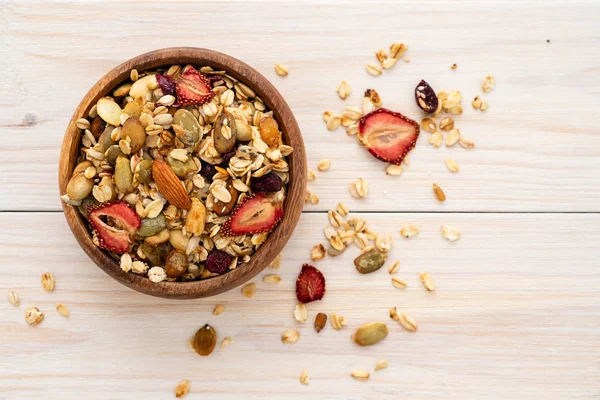 Kase yulaf granola, taze ahududu, yaban mersini ve sağlıklı kahvaltı için Beyaz ahşap tahta fındık. üstten görünüm