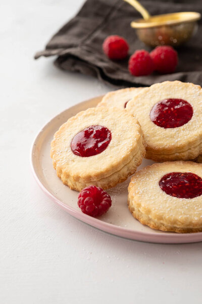 Traditional Christmas Linzer cookies with sweet jam on plate, closeup, copy space.