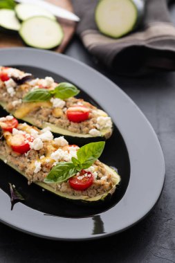 Kıyılmış et ile dolması kabak siyah bir zemin üzerine peynir. Fırında pişmiş. Kopya alanı.