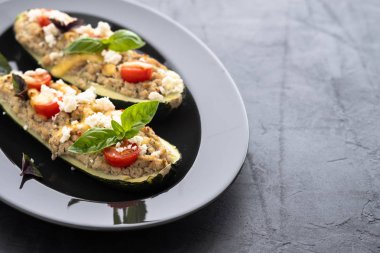 Kıyılmış et ile dolması kabak siyah bir zemin üzerine peynir. Fırında pişmiş. Kopya alanı.