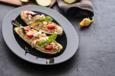 Kıyılmış et ile dolması kabak siyah bir zemin üzerine peynir. Fırında pişmiş. Kopya alanı.