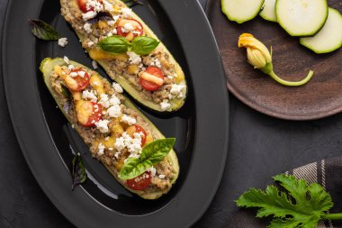 Kıyılmış et ile dolması kabak siyah bir zemin üzerine peynir. Fırında pişmiş. Kopya alanı.